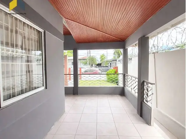 Covered front porch with tiled floor and decorative iron grilles
